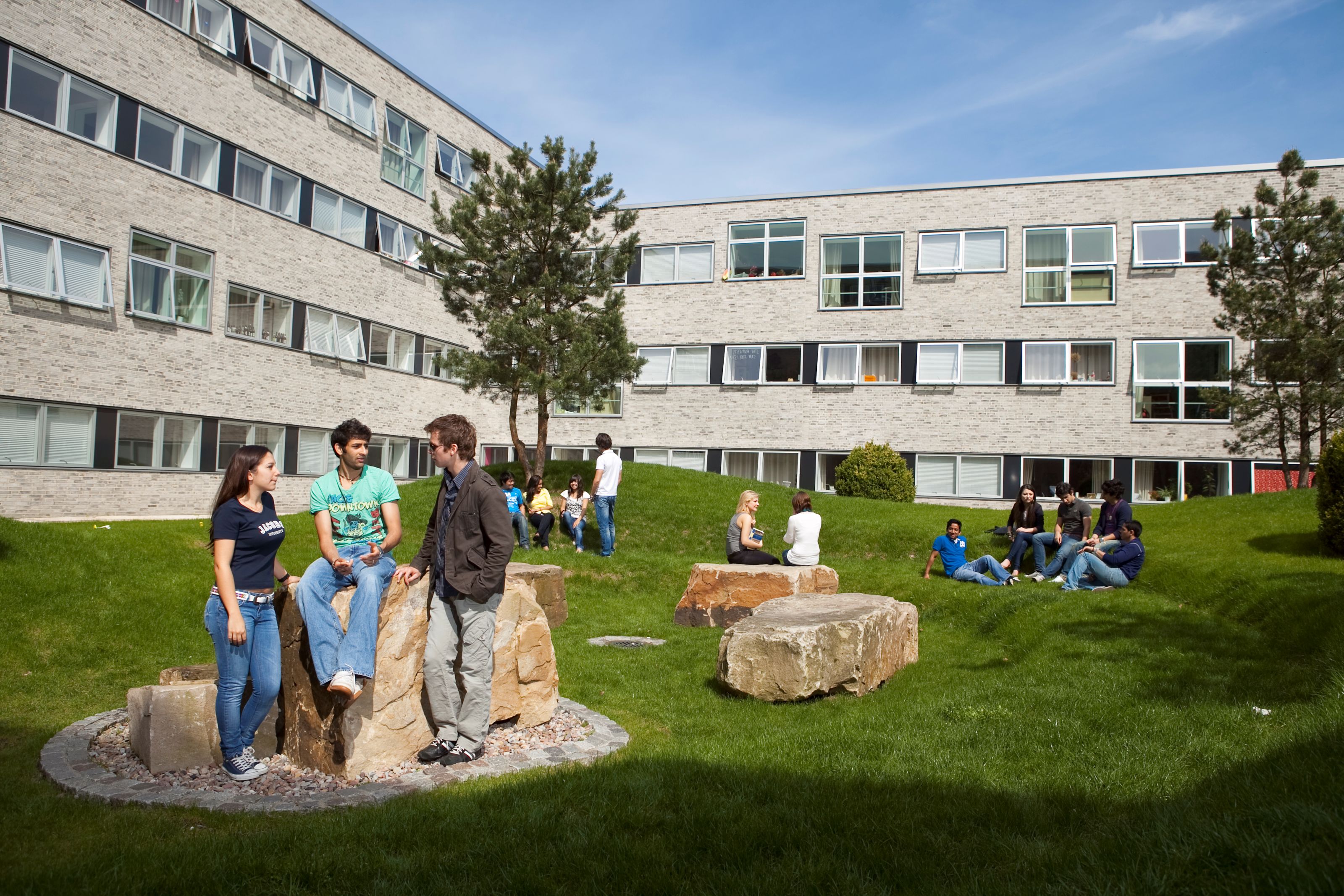 Students gathered around college dormitory.