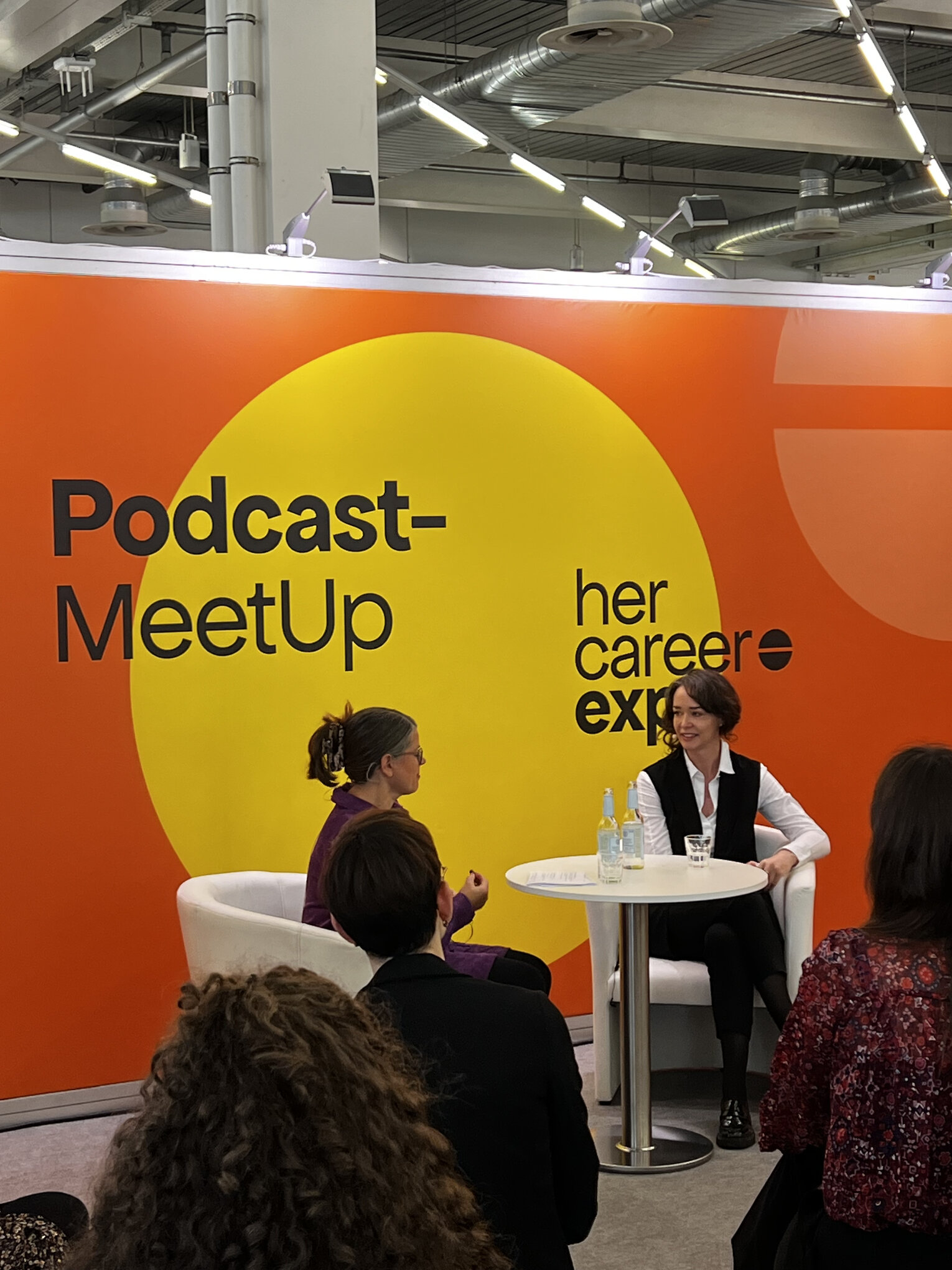 Two women speaking at a podcast meetup during the herCAREER Expo