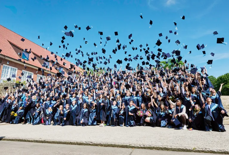 Students celebrating their graduation with the hat toss