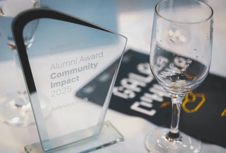 Close-up of a glass trophy for the 2025 Community Impact Alumni Award