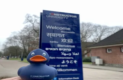 Joana in front of welcome sign