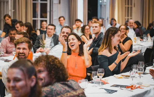 Alumni applauding during a celebratory dinner event