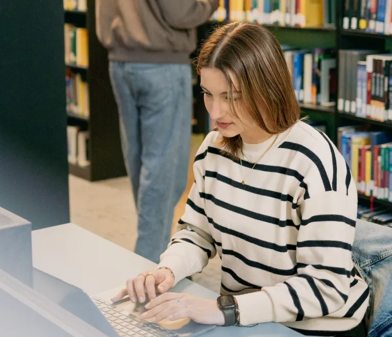 Student working on a laptop in the IRC