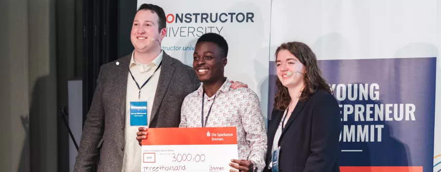 Steven Kibande (Mitte) von der Mbarara Universität in Uganda, holte mit seinem Start-up Kanga Care den ersten Platz beim Young Entrepreneur Summit, organisiert von Oscar Kirkwood (li.) und Thea Mischel (re.). (Quelle: Constructor University)