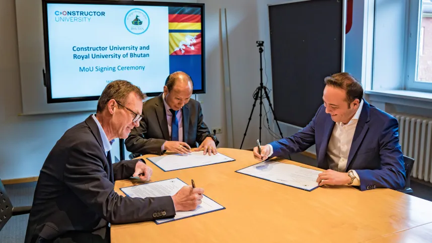 Provost Dr. Frazer Cairns, Vice Chancellor Dasho Chewang Rinzin and Chancellor Turgut Tülü (from left to right) signing the first MoU between Constructor University and the Royal University of Bhutan.