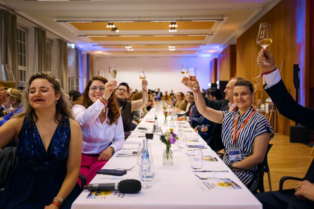 Alumni raising their glasses at formal celebration dinner